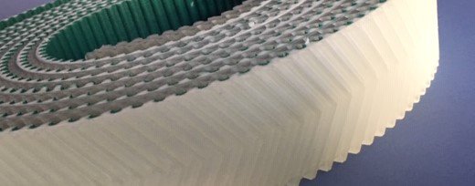 Courroie dentée avec revêtement en forme d'arête de poisson pour les tables de découpe